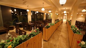 Un restaurant amb seients de fusta, grans finestres i lluminàries penjants.