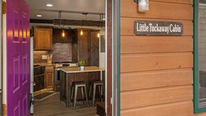 Une cuisine avec des meubles en bois, un mur en briques et une enseigne indiquant « Little Tuckaway Cabin ».
