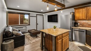 Une cuisine moderne dotée d’un îlot central, de meubles en bois et d’un four encastré.