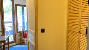 A room with a wooden door, a small table, and a chair. - Renovated 16m² studio, close to slopes, Avoriaz (Avoriaz)