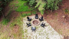 An outdoor seating area with six black chairs arranged around a central fire pit. - Lakefront 3BR w/ Private Dock + Firepit | Free Tix (Mill Spring)