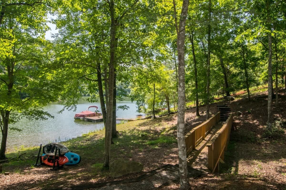 A serene lakeside setting with a wooden deck and a kayak.