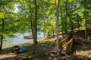 A serene lakeside setting with a wooden deck and a kayak. - Lakefront 3BR w/ Private Dock + Firepit | Free Tix (Mill Spring)