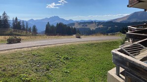 Vista desde un balcón sobre una carretera, con una cadena montañosa al fondo.