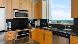 Una cocina moderna con gabinetes de madera, un microondas de acero inoxidable y un lavavajillas.