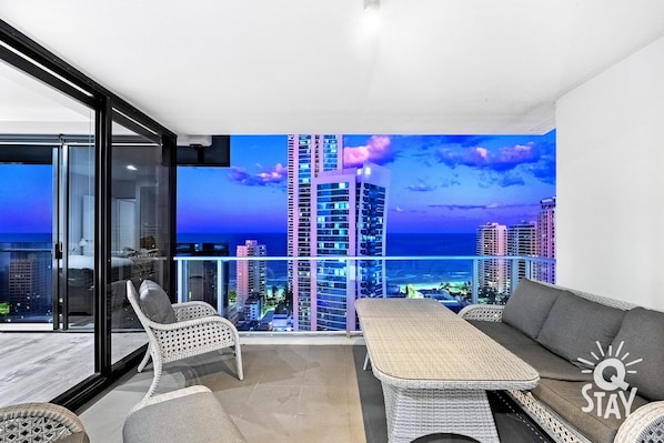 Enjoy a panoramic city view from the balcony, relax in the seating area, and unwind with entertainment options.