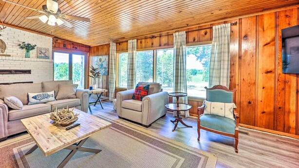 A cozy living room with a wooden ceiling, a fireplace, a sofa, a chair, and a coffee table. - 'Lochview Lodge' Idyllic Farmhouse in Grove! (Grove)