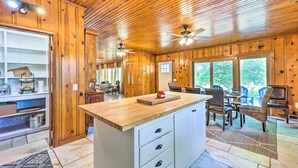 A wooden interior with a kitchen island, dining area, and large windows. - 'Lochview Lodge' Idyllic Farmhouse in Grove! (Grove)