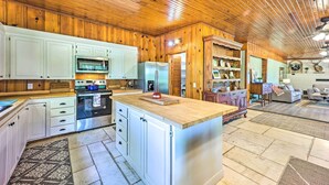 A spacious kitchen with wooden cabinets, a large island, and modern appliances. - 'Lochview Lodge' Idyllic Farmhouse in Grove! (Grove)