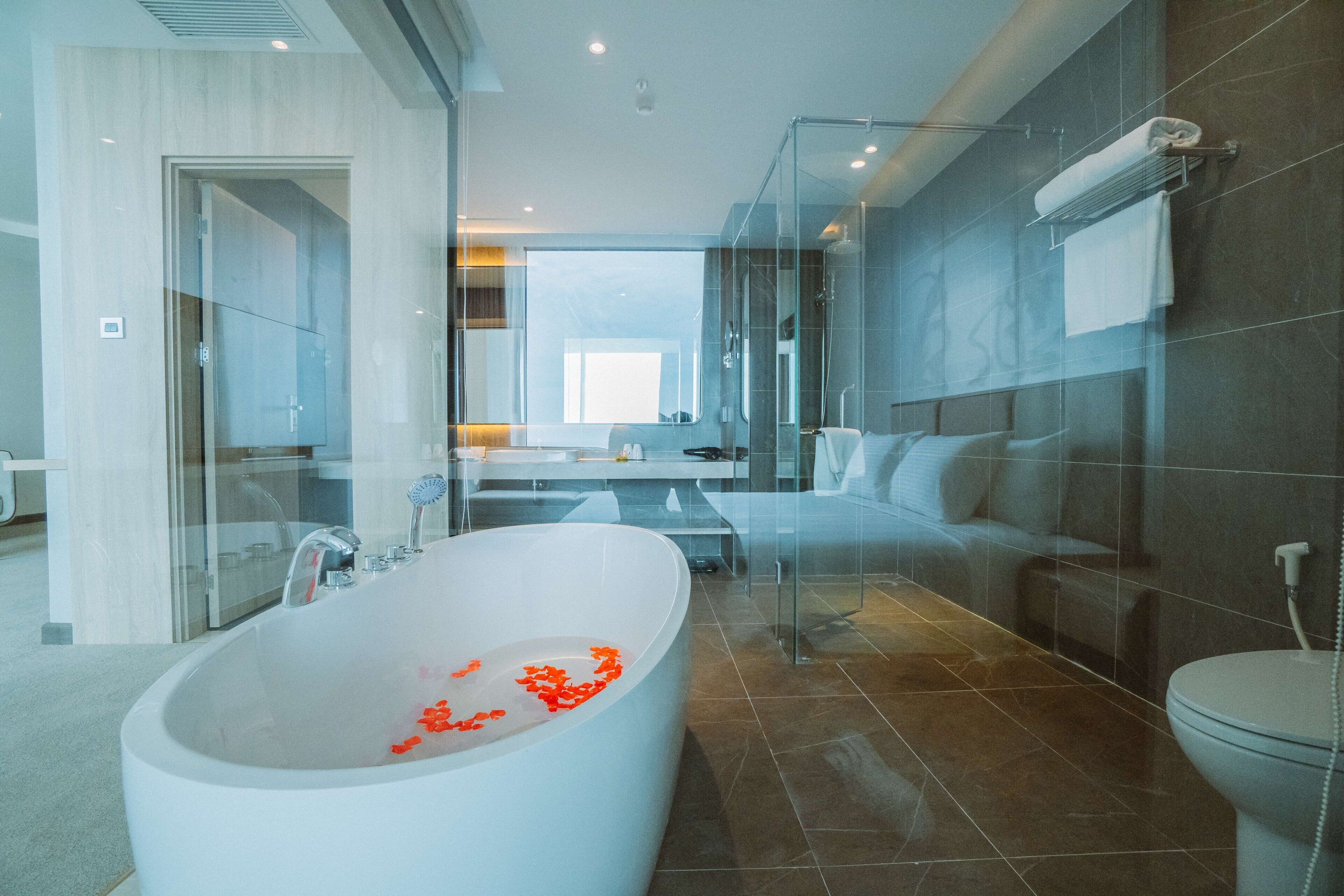 A modern bathroom with a freestanding bathtub, a glass shower enclosure, and a large mirror.
