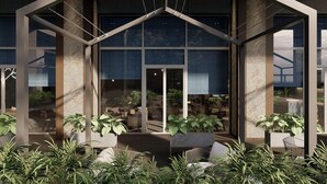 A modern building with a triangular roof structure, large windows, and indoor seating areas with plants. - Muong Thanh Luxury Xuan Thanh Hotel (Tien Dien)