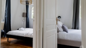 Un dormitorio con cama, lámpara y ventana.