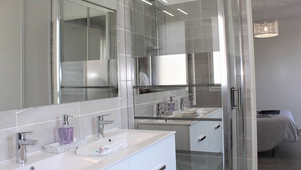 A modern bathroom with a large mirror, two sinks, and a shower area. - New 3-Room Apartment with Terrace and Garage, Cagnes-sur-Mer (Cagnes-sur-Mer)