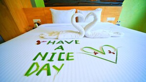 A neatly made bed with a swan and heart-shaped decorations, and the phrase "HAVE A NICE DAY" written on the bed. - Royal Rich County (Gangavathi)