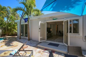 Une maison moderne dotée d’une entrée accueillante, d’une terrasse en pierre et d’une piscine.