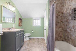 Ein Badezimmer mit Dusche, Toilette und Waschtisch.