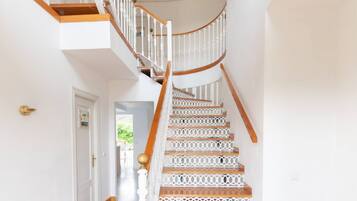 A staircase with white balustrades and wooden steps leading to an upper floor.