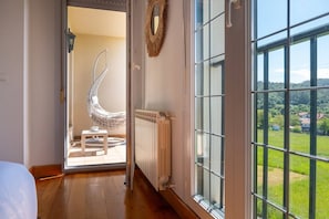 A room with a view of a green landscape through large windows, a white radiator, and a hanging chair. - 5 bedroom accommodation in Norte (Piélagos)