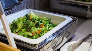 Een buffet met diverse groenten, waaronder broccoli en wortels.