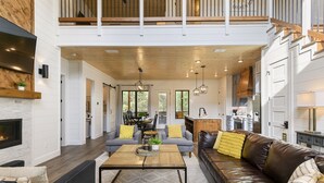 Amplia sala de estar con chimenea, comedor y cocina.