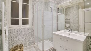 A modern bathroom with a glass-enclosed shower, a large mirror, and a white sink. - Superb Apartment 100 Meters From the Port of Nice (Nice)
