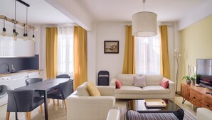 A modern living room with a sofa, dining table, and kitchen area. - Superb Apartment 100 Meters From the Port of Nice (Nice)