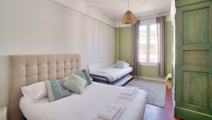 A hotel room with a large bed, a smaller bed, and a green door. - Superb Apartment 100 Meters From the Port of Nice (Nice)