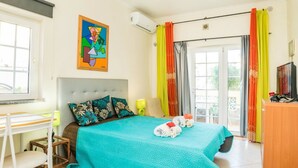 Ein Schlafzimmer mit Bett, Schreibtisch, Stuhl, Fenster und einem Bild an der Wand.