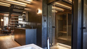 A modern bathroom with a glass-enclosed shower, a large bathtub, and a kitchen area with a bar. - Hotel ONIRO - Luxury Rooms & Wellness Suites (Tournai)