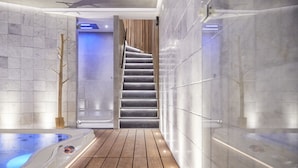 A modern spa area with a wooden floor, a hot tub, and a staircase leading to a higher level. - Hotel ONIRO - Luxury Rooms & Wellness Suites (Tournai)