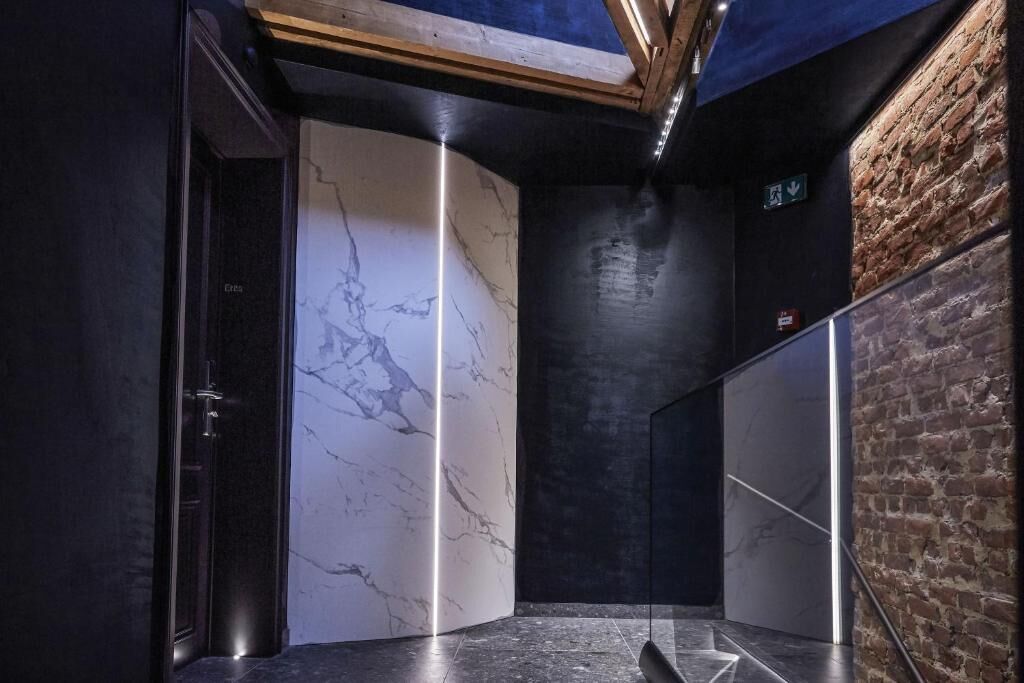 A modern elevator with marble walls and a wooden ceiling.