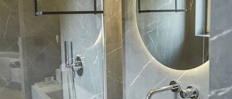 A modern bathroom with a glass-enclosed shower, a marble vanity, and a large mirror.