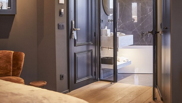 A modern bedroom with a large bed, a wooden ceiling, and a glass door leading to a bathroom. - Hotel ONIRO - Luxury Rooms & Wellness Suites (Tournai)