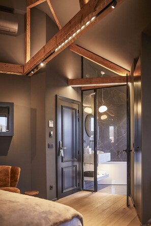 A modern bedroom with a large bed, a wooden ceiling, and a glass door leading to a bathroom. - Hotel ONIRO - Luxury Rooms & Wellness Suites (Tournai)