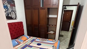 A bedroom with a bed, a wardrobe, a mirror, and a door. - Come to me (Cali)