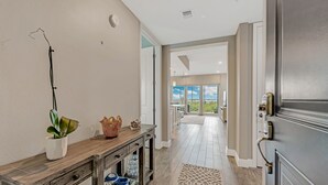 A hallway with a wooden console table, a potted plant, and baskets.