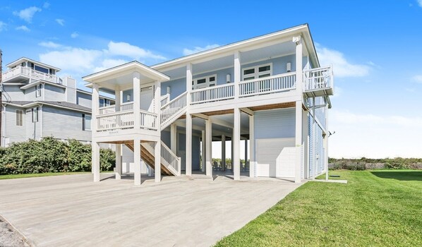 A two-story house with a covered porch, a garage, and a landscaped yard.