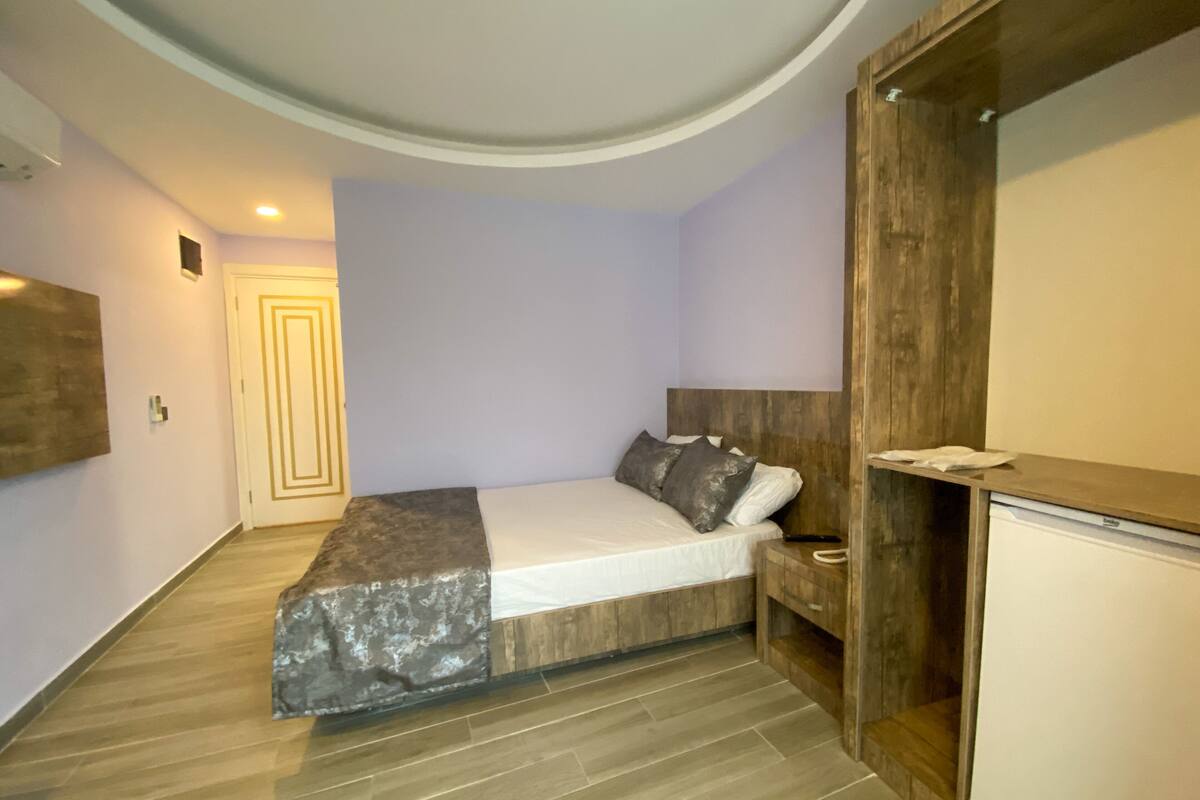 A bedroom with a bed, bedside table, and a built-in wardrobe.