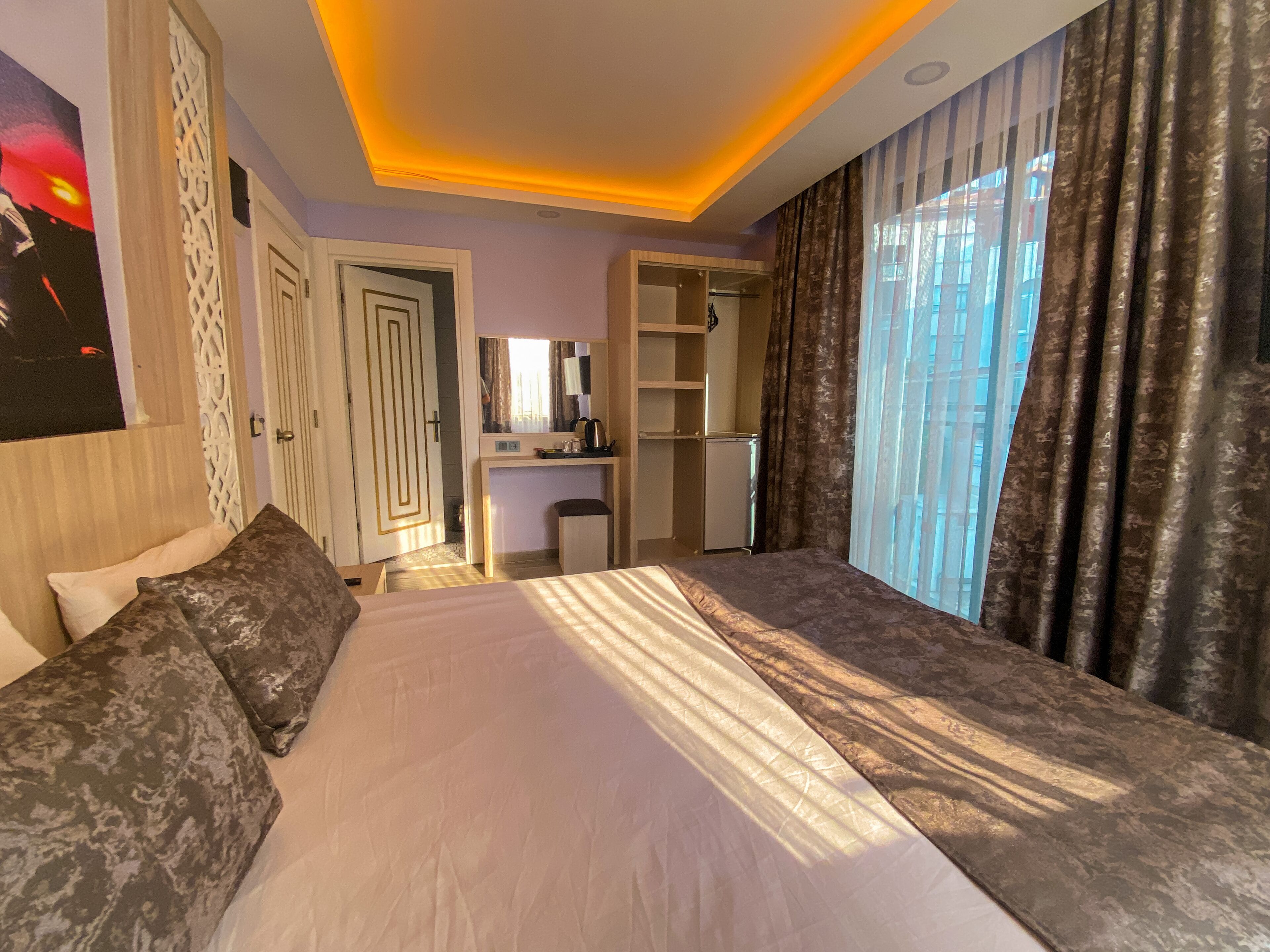Ein Hotelzimmer mit einem großen Bett, einem Schreibtisch und einem Kleiderschrank.