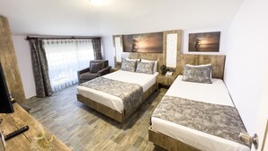 A hotel room with two beds, a sofa, a TV, and a wooden floor. - Castle's Light Boutique Hotel (Alanya)