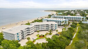 Un hôtel en bord de mer, composé de plusieurs bâtiments, avec une plage et une vue dégagée sur l’océan.