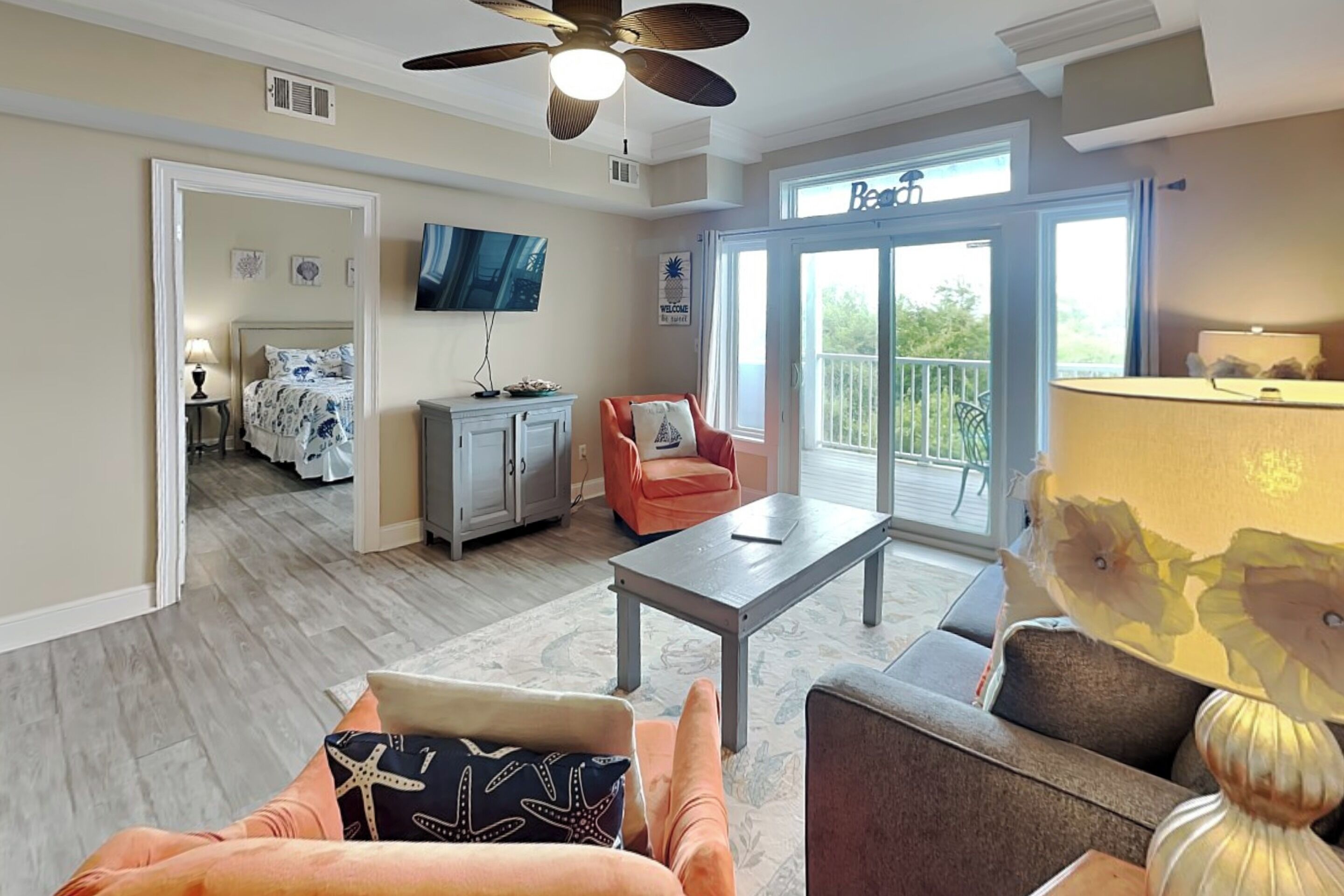 A spacious living area with a ceiling fan, a flat-screen TV, a dining table, and a comfortable seating arrangement.