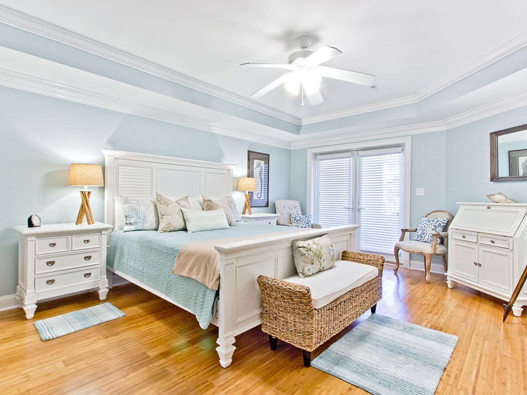 A bedroom with a bed, nightstands, a dresser, a chair, and a ceiling fan.