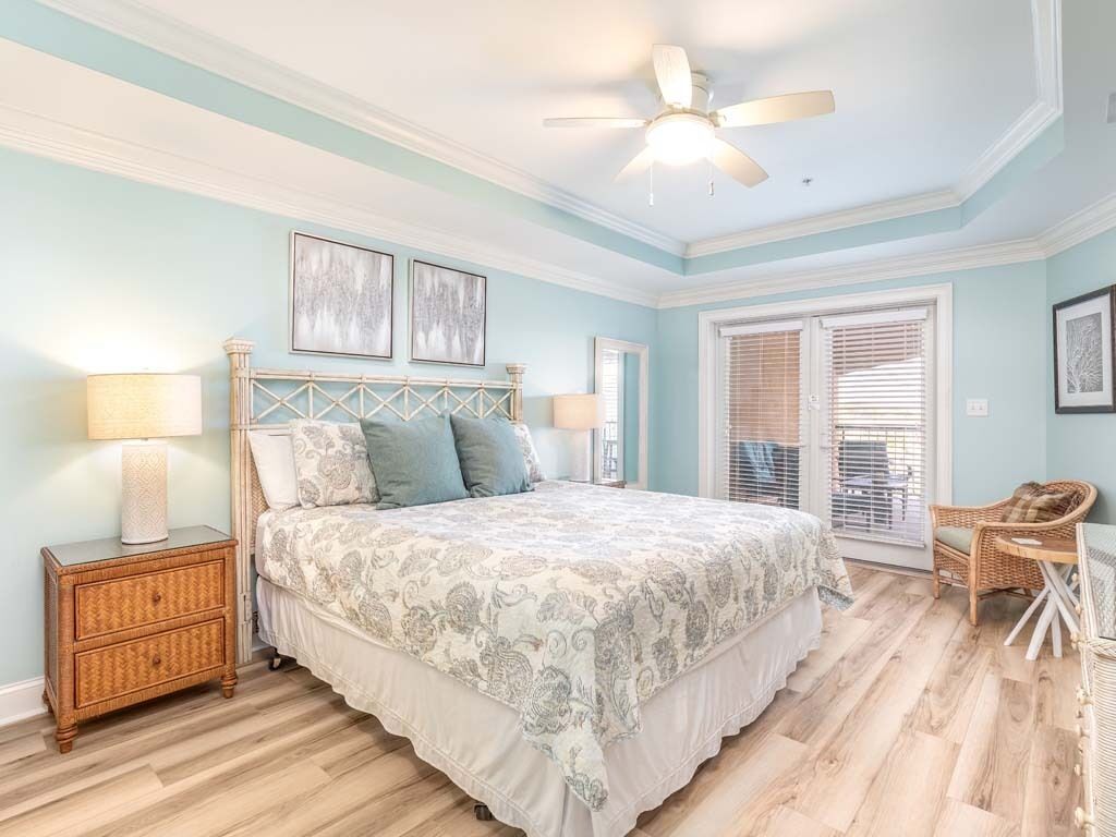 A bedroom with a bed, nightstands, a ceiling fan, and a window with blinds.