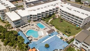 Eine Vogelperspektive eines Hotels mit mehreren Gebäuden, einem Schwimmbecken und Außenbereichen mit Sitzgelegenheiten.