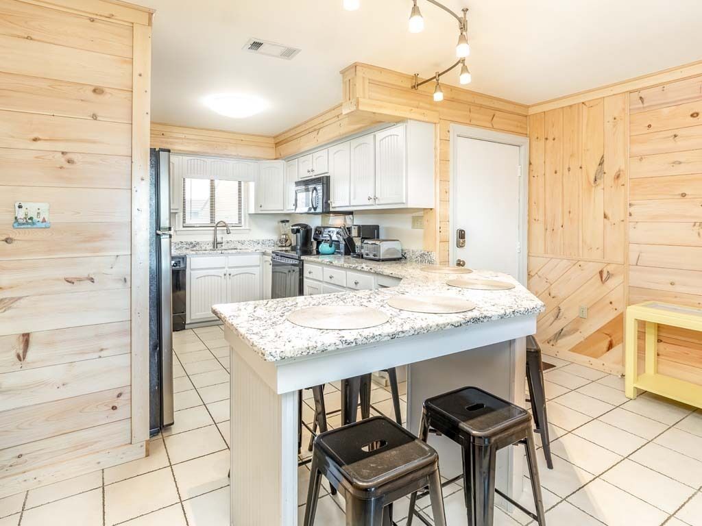 A modern kitchen with white cabinets, granite countertops, and stainless steel appliances.