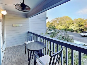 Enjoy a peaceful outdoor space with a round table and two chairs, perfect for taking in the views of the surrounding trees.