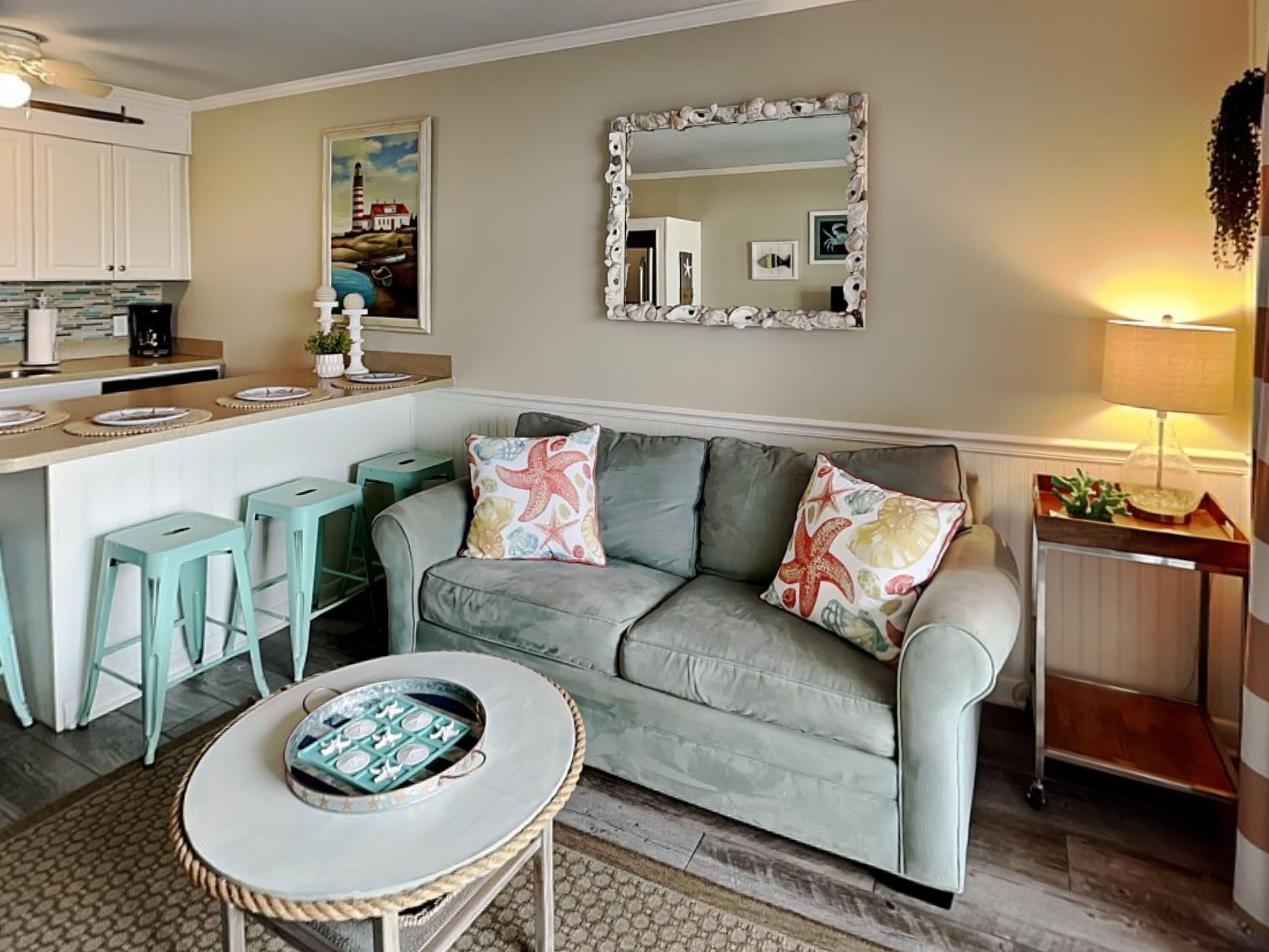 A cozy living area with a sofa, a small round table, and a kitchen in the background.