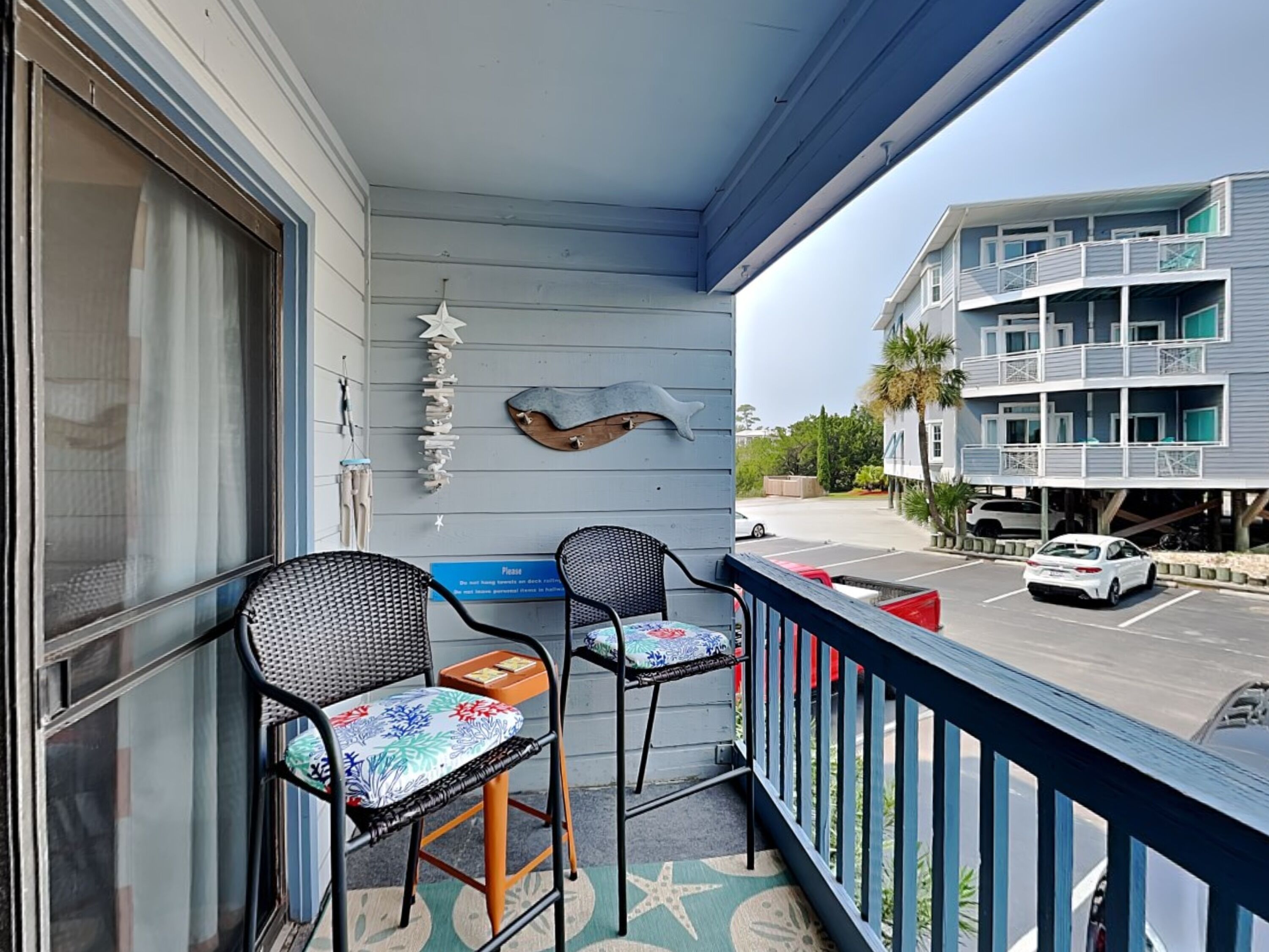 A balcony with two chairs and a starfish decoration.