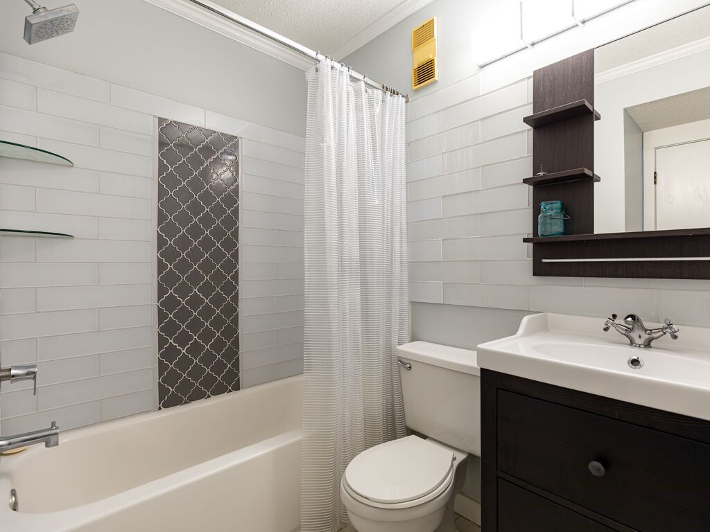 A bathroom with a bathtub, toilet, and sink.